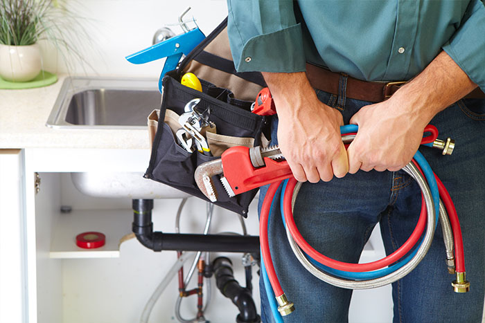 plumber holding pipes and tools